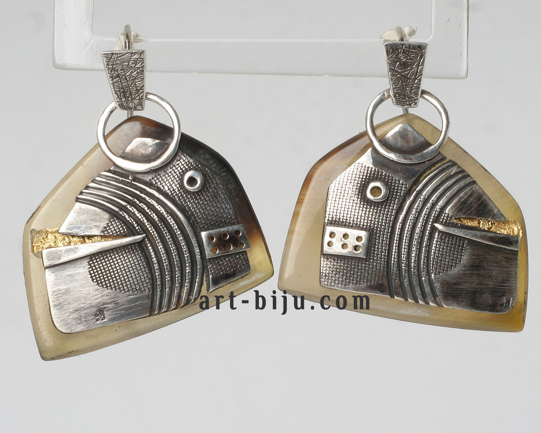 Boucles d'oreilles en argent avec corne et accent doré.